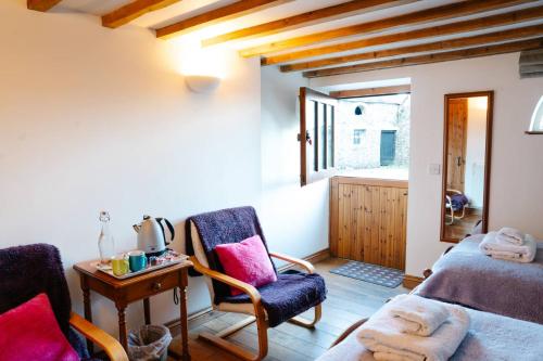 a room with two chairs and a bed and a table at Henllys Estate B and B in Llandovery