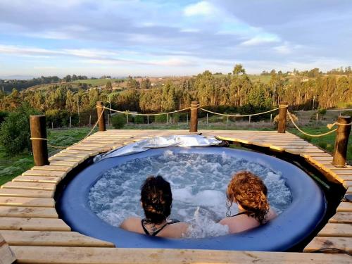 サント・ドミンゴにあるDomo en la Reserva El Yali, con jacuzzi privadoの2人の女性がジャグジータブに座っています