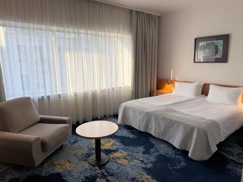 カウナスにあるベスト バルティック カウナスのベッドと椅子と窓のあるホテルの部屋