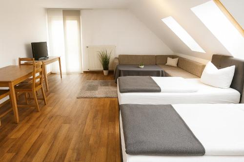 1 Schlafzimmer mit 2 Betten, einem Tisch und einem Schreibtisch in der Unterkunft SUNNYHOME Monteurwohnungen und Apartments in Schwandorf in Schwandorf in Bayern
