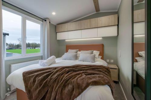 une chambre avec un grand lit avec une grande fenêtre dans l'établissement Bower lodge 72, à Cameron