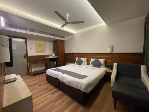 a hotel room with a bed and a chair at Hotel LOTO Premier Vijay Nagar in Jāmb