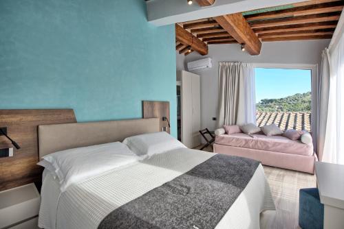 a bedroom with a bed and a couch at Villa Acquaviva with Panoramic, Private Pool and Gym - by PosarelliVillas in Panicale