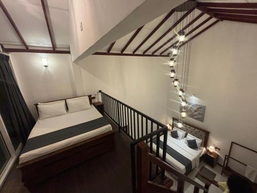a room with two beds and a staircase with lights at Mountain Bliss - Ingiriya in Ingiriya