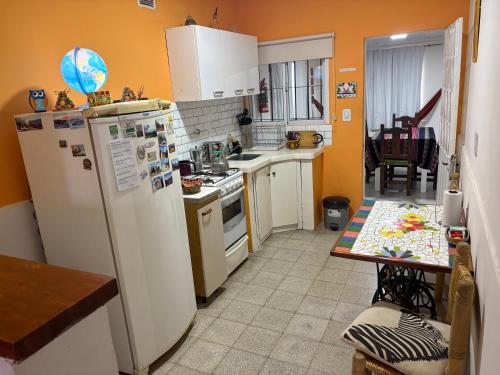 a kitchen with a refrigerator and a table in it at "La Violeta" casa con jardín y cochera, San Pedro in San Pedro