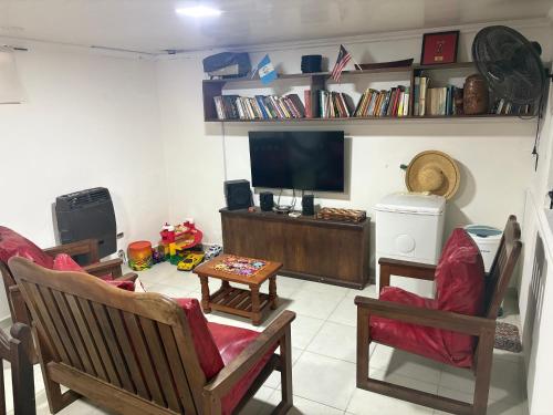 a living room with two chairs and a tv at "La Violeta" casa con jardín y cochera, San Pedro in San Pedro