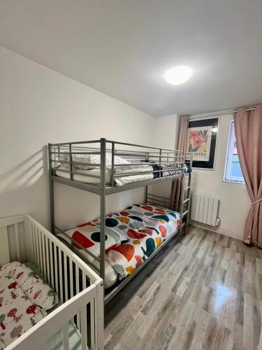 2 stapelbedden in een kamer met houten vloeren bij Gîte la perle rose 50 m² in Orchies