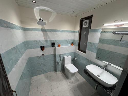 a bathroom with a toilet and a sink at NE Heritage Residency in Guwahati