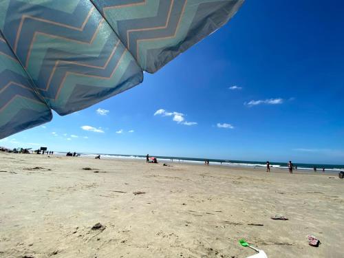 Casa en Barra del Chuy-Alvorada reserva con Seña !! في بارا ديل تشوي: مجموعة من الناس على شاطئ فيه مظلة