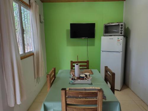 cocina verde con mesa y nevera en Cabañas Maturrango - Jáchal, San Juan, 
