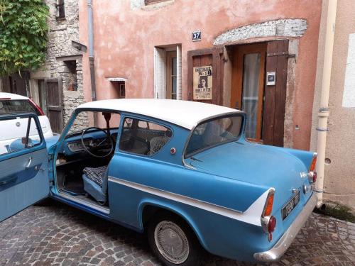 un'auto blu parcheggiata accanto a un edificio di Le terrier des sorciers a Crémieu