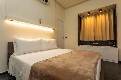a bedroom with a large white bed with a window at Marina Home - Luxury Apartament in Stazione Catania Porto