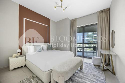 a bedroom with a white bed and a chair at Bloomfields Elegance 2br Ajwan Soul Beach Access in Abu Dhabi