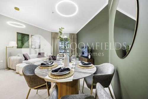 a living room with a table and chairs at Bloomfields Elegance 2br Ajwan Soul Beach Access in Abu Dhabi
