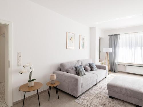 a white living room with a couch and a table at Exklusive Wohnung mit Ahrblick 3 in Bad Neuenahr-Ahrweiler