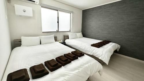 zwei Betten nebeneinander in einem Zimmer in der Unterkunft Grandioso Onna 7-D - Vacation STAY 17394v in Atsutabaru