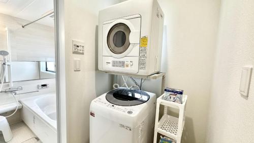 Waschmaschine und Trockner in einem kleinen Bad in der Unterkunft Grandioso Onna 7-D - Vacation STAY 17394v in Atsutabaru