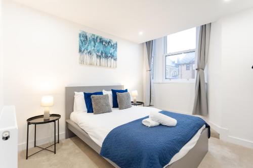 a bedroom with a large bed with blue and white at The Townhouse Collection 2BR Close To City Centre in Cardiff