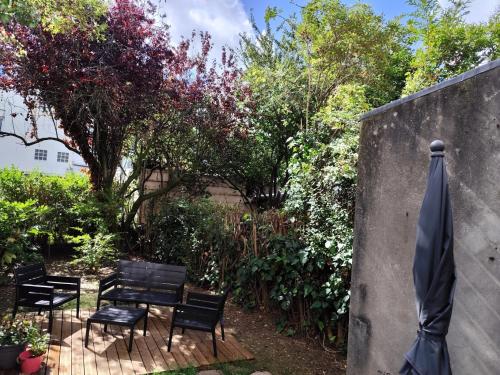 a patio with chairs and a table and a umbrella at La Suite by Nath in Calais