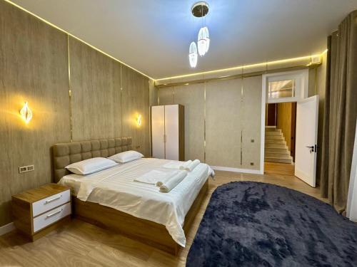 a bedroom with a large bed and a blue rug at Town House in Samarkand