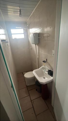 ein kleines Badezimmer mit Waschbecken und Toilette in der Unterkunft Linda casa para suas férias ! in Imbé