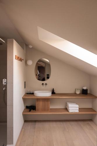a bathroom with a sink and a mirror at normalkonsum - premium apartments in St. Gallen