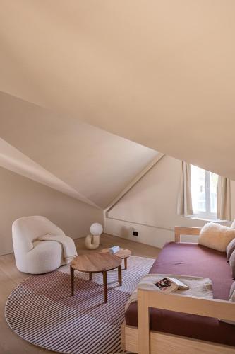 a attic bedroom with a bed and a table at normalkonsum - premium apartments in St. Gallen