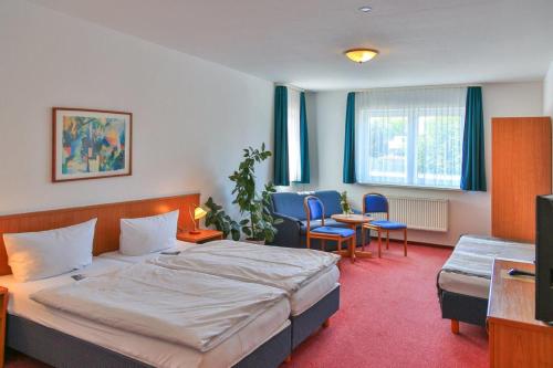 a hotel room with a bed and a table and chairs at Zum Alten Schweden in Wolgast