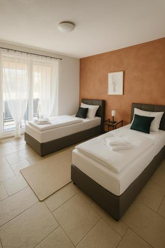 a bedroom with two beds and a window at SUNNYHOME Ferienwohnung am Brückelsee in Wackersdorf