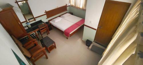 een kleine kamer met een bed en een tafel en stoelen bij The Boat Jetty Bungalow in Cochin