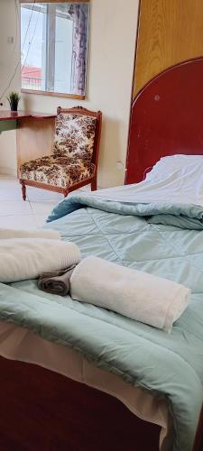 ein Schlafzimmer mit zwei Betten, einem Stuhl und einem Fenster in der Unterkunft To Σπιτι του Θωμά in Kardítsa