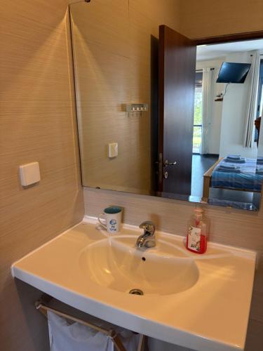 a bathroom with a sink and a mirror at Greek Relaxation in Ma‘yan Barukh