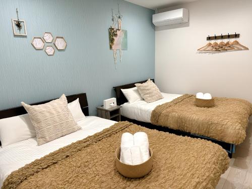 two beds in a room with blue walls at Grandioso Okinawa Villa Kin 2 - Vacation STAY 90150v in Yaka