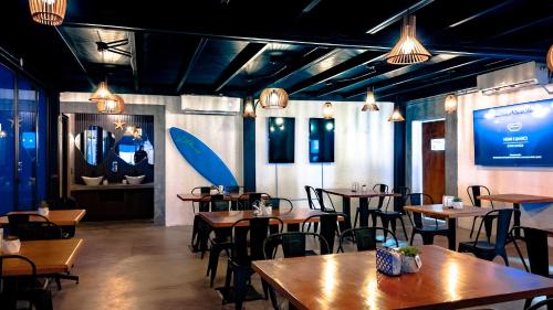 a restaurant with wooden tables and chairs and a large screen at InHouse Glamping Hotel La Paz in La Paz