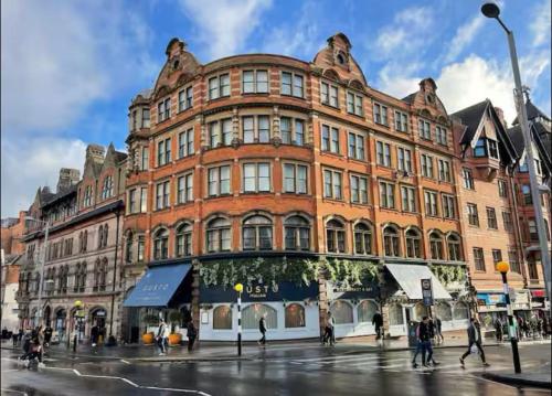 a large red brick building on a city street at Heart of Notts, Corner Top View Modern & Cosy Studio in Nottingham