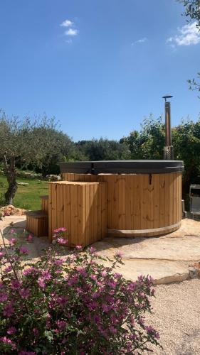 a wooden building with a wooden fence and flowers at Dimora Il Mandorlo con jacuzzi riscaldata in Ostuni