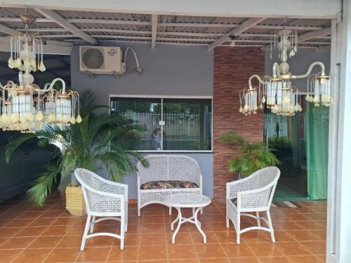 a patio with chairs and a table and chandeliers at Residencial Celedone in Boa Vista