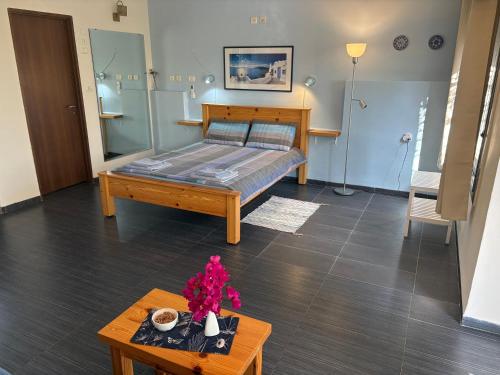 a bedroom with a bed and a table with flowers on it at Greek Relaxation in Ma‘yan Barukh