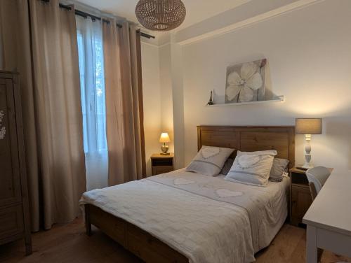 a bedroom with a bed with white sheets and a window at Chambre privée chez Ourdia in Thiais