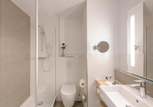 a bathroom with a toilet and a sink and a shower at Mercure Hotel Erfurt Altstadt in Erfurt