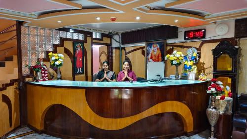 Duas mulheres sentadas num bar na entrada. em Hotel Gokul Plaza em Bhubaneshwar
