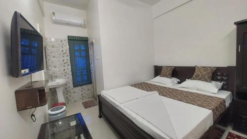 um quarto com uma cama e uma televisão em Hotel Gokul Plaza em Bhubaneshwar
