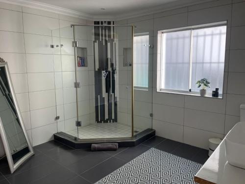a shower stall in a bathroom with a window at Oceana Views in Gordonʼs Bay