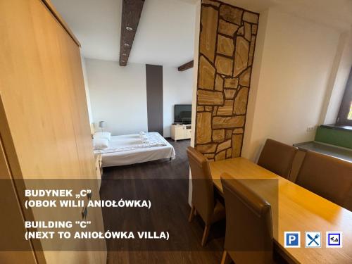 a room with a bed and a table and chairs at Willa Aniołówka in Kościelisko