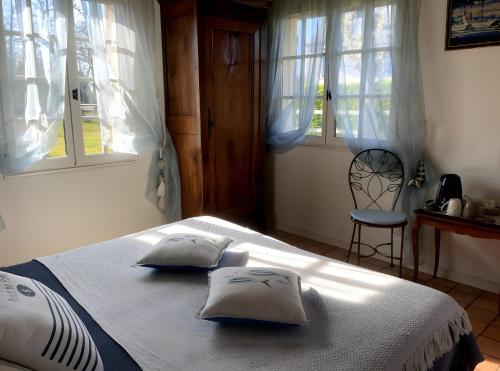 a bedroom with a bed with two pillows on it at Manoir du Petit Saint-Pierre in Côte de Grâce