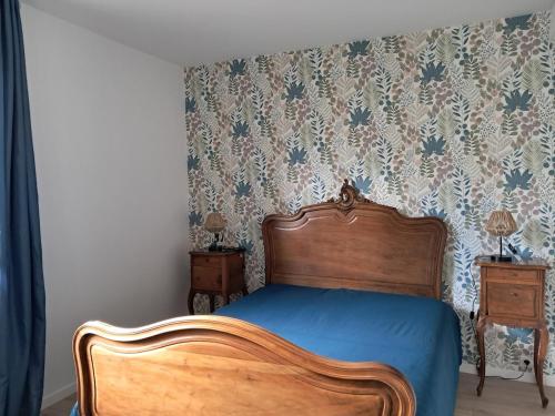 a bedroom with a wooden bed with a blue bedspread at Maison aux portes du centre historique de Dijon avec 3 chambres et garage in Dijon