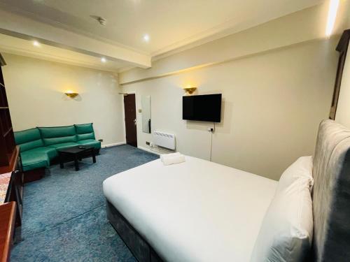 a hotel room with a bed and a couch and a tv at TCH Lodge in Bolton