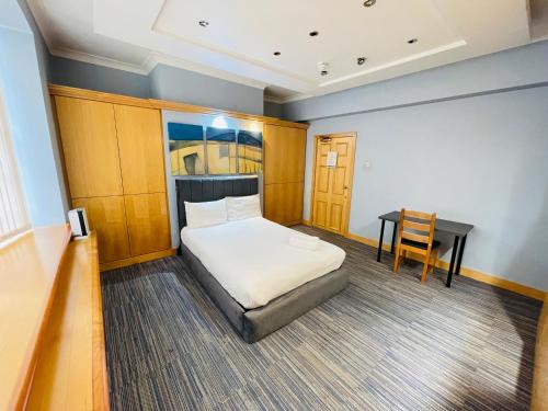a small bedroom with a bed and a desk at TCH Lodge in Bolton