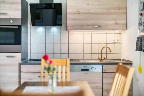 MühlenbachにあるCafé Pension Pfaus 1 fewo-4 Zimmerのキッチン(テーブル、椅子、シンク付)