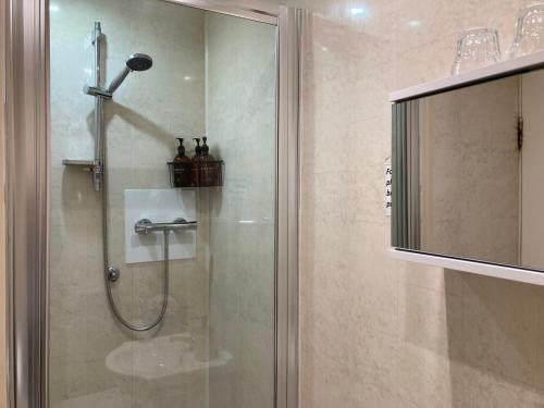a shower with a glass door in a bathroom at The Buck Inn in Whitby